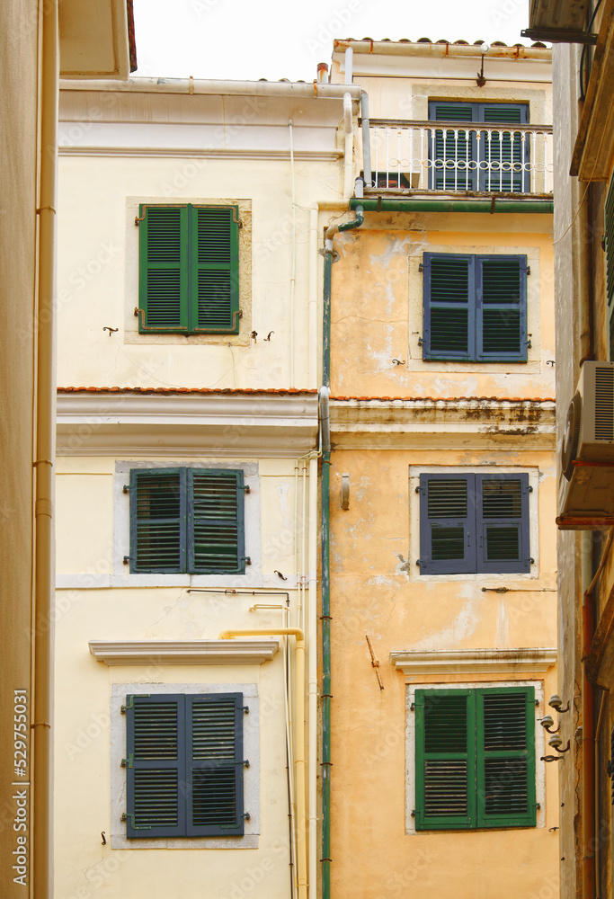 Blick durch eine Gasse auf typische Häuser in Korfu-Stadt, vertikal 