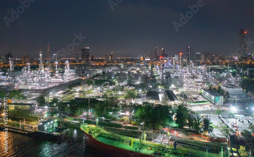 Aerial view of petrochemical oil refinery and sea in industrial engineering concept in Bangna district at night  Bangkok City  Thailand. Oil and gas tanks pipelines in industry. Modern metal factory.