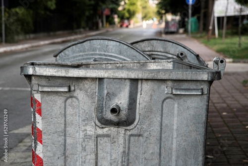 close up of a metal garbage container on the side of a road in Skopje