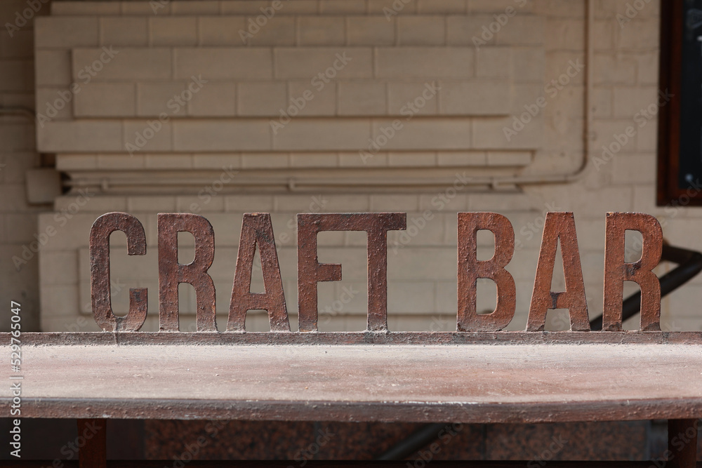 Obraz premium Iron signboard Craft Bar and bar counter. Entrance to a craft beer establishment.