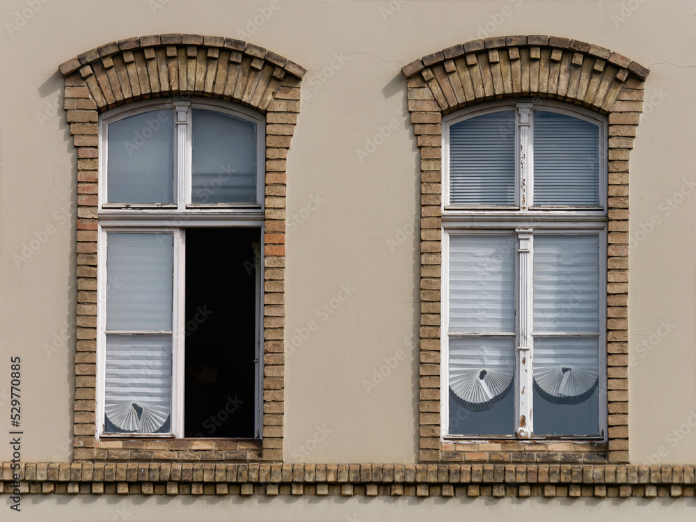 Front view of two vintage-style windows on a brown facade