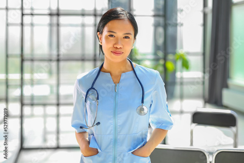 Fotografie Portrait of asian female doctor holding hands and smiling