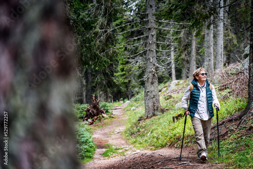 Obraz na płótnie Active happy mature senior woman walking in beautiful autumn forest w salonie