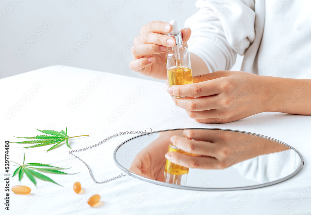 cbd oil in hands. Pharmaceutical medicine pills, capsules on a white table. Concept Melatonin production and restore sleeping routine. cbd oil in hands. Pharmaceutical medicine pills, capsules on a white table. Concept Melatonin production and restore sleeping routine.