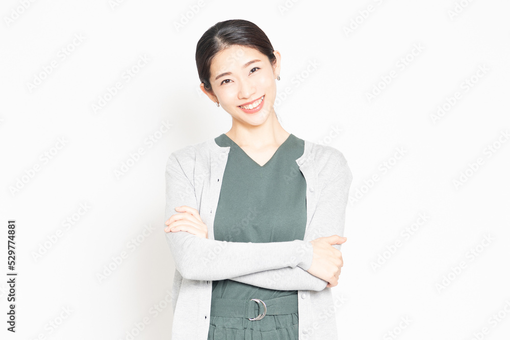 白背景の前で腕組みをしている笑顔の女性