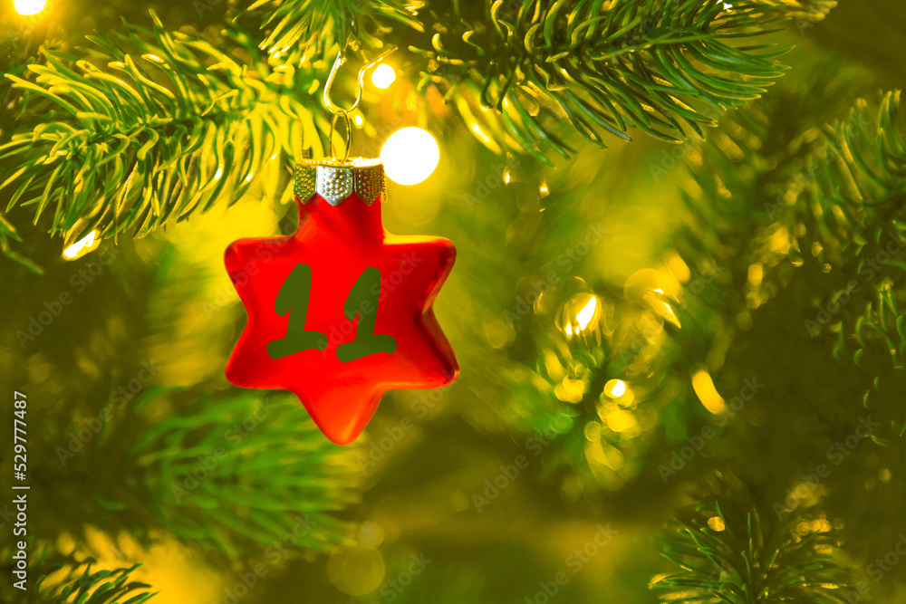 ein roter Stern mit einer Zahl (11) am Weihnachtsbaum, Weihnachtskalender
