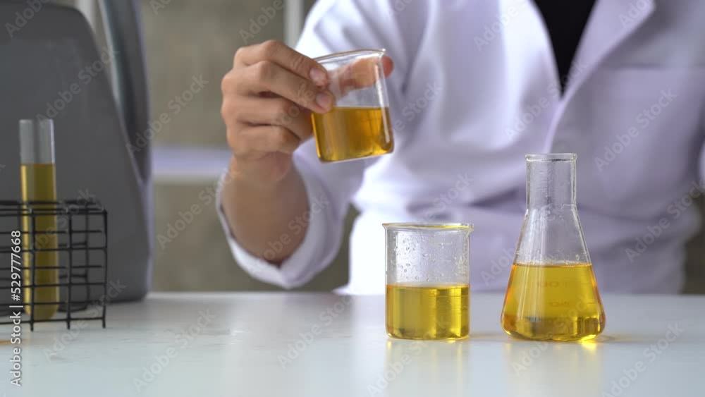 Close up lap worker test and pours car engine oil quality test, checking and compare color difference. Close up lap worker test and pours car engine oil quality test, checking and compare color difference.