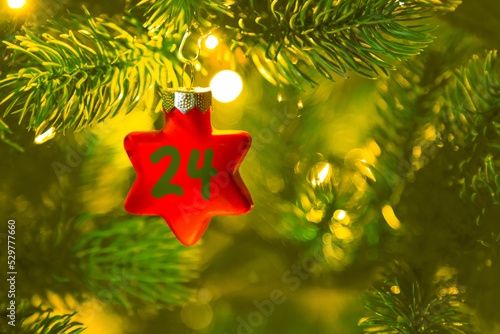 Obraz na płótnie ein roter Stern mit einer Zahl (24) am Weihnachtsbaum, Weihnachtskalender w salonie