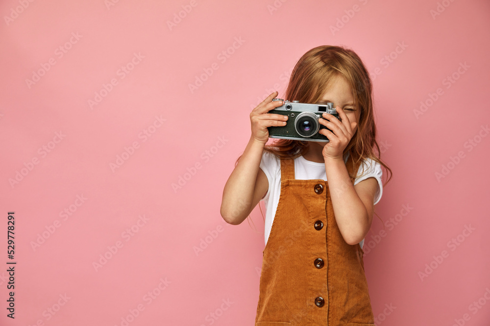 Beautiful smiling child (kid, girl) holding a instant camera Beautiful smiling child (kid, girl) holding a instant camera