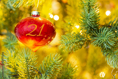 eine rote Weihnachtskugel mit einer Zahl (21) am Weihnachtsbaum, Weihnachtskalender
