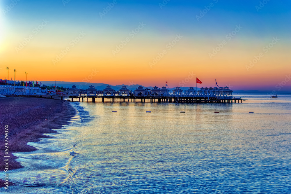 Fototapeta premium Empty beach with sun beds and sun shades during early summer morning