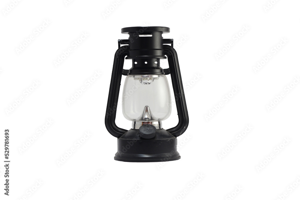 An old black lamp shines brightly isolated from a white background. An old black lamp shines brightly isolated from a white background.