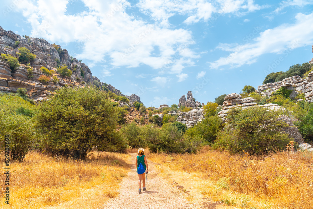 A young woman trekking in the Torcal de Antequera on the green and yellow trail, Malaga. Spain