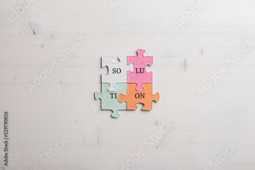 Word Solution spelled with syllables on four matching colorful puzzle pieces photo