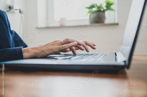 Businesswoman or secretary working at her office desk using laptop computer Fototapet