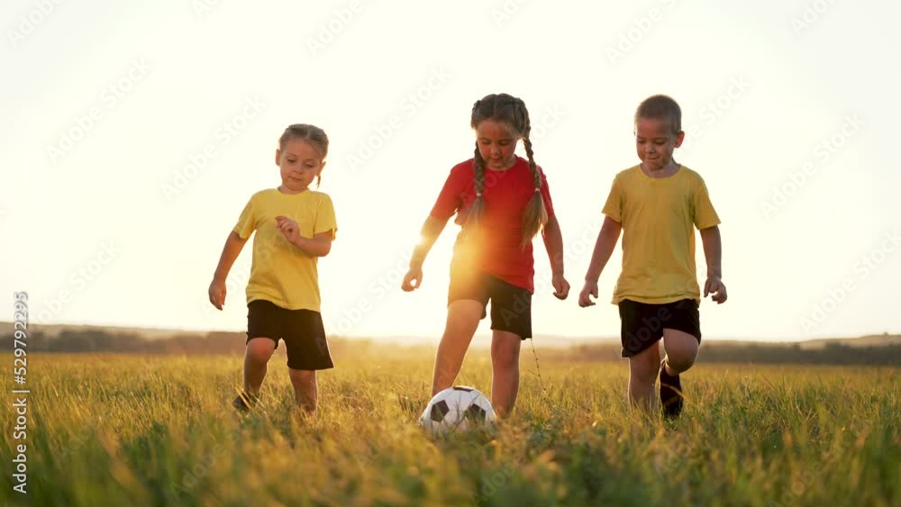 Happy family of children run across field. Group of children are playing with soccer ball. Happy family in park.Ball game in park. Family soccer game. Happy children in park run with ball.Happy family Happy family of children run across field. Group of children are playing with soccer ball. Happy family in park.Ball game in park. Family soccer game. Happy children in park run with ball.Happy family