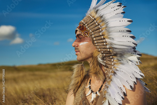 Photos A man in traditional Native American clothing in the steppe