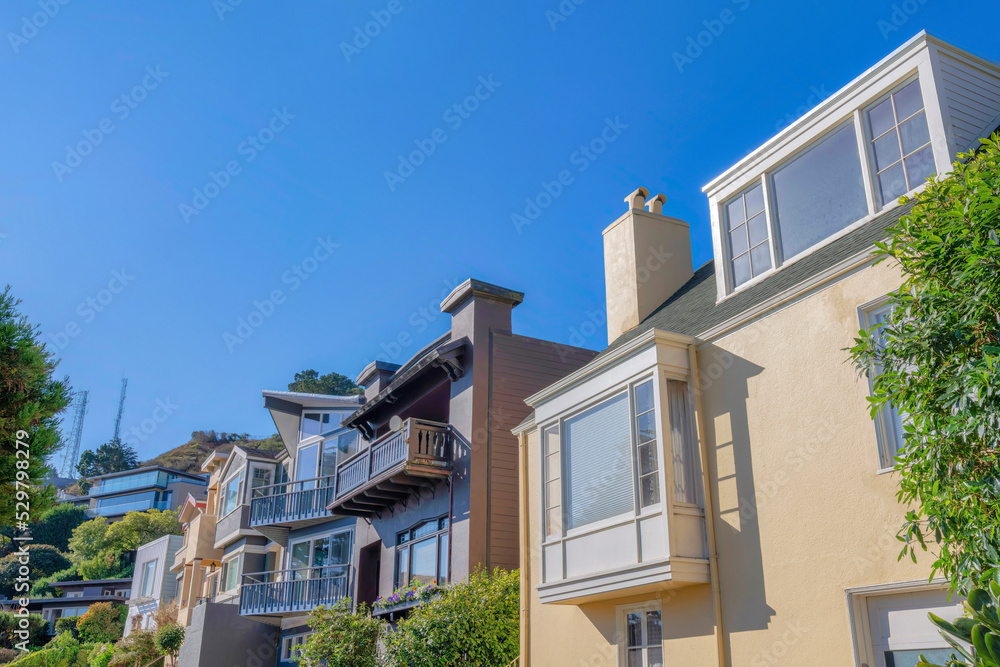 Row of suburban houses near a slope with two towers at the back in San Francisco, California