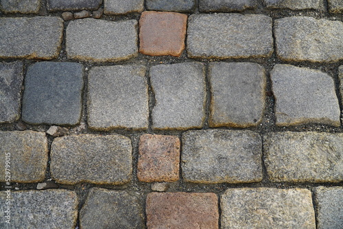 Historic old cobblestones of Herren Street in the old town of Plauen, Vogtlandkreis, Saxony, Germany. Old pavement road. Texture of stone pavement tiles.