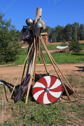 shields, spears and helmets on a rack in a historical camp, historical reconstruction
