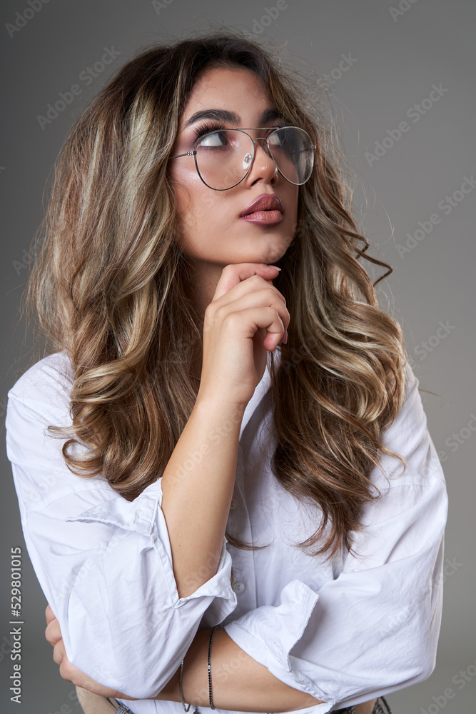 Attractive young business woman in glasses on gray