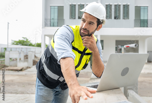 Engineer man working at construction site using laptop computer and wireless technology for business meeting on building development project. Professional contractor, construction engineering concept