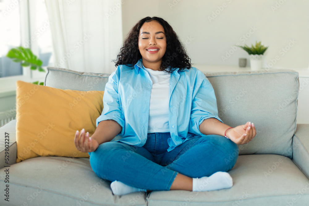 African American Lady Meditating With Eyes Closed Sitting At Home African American Lady Meditating With Eyes Closed Sitting At Home