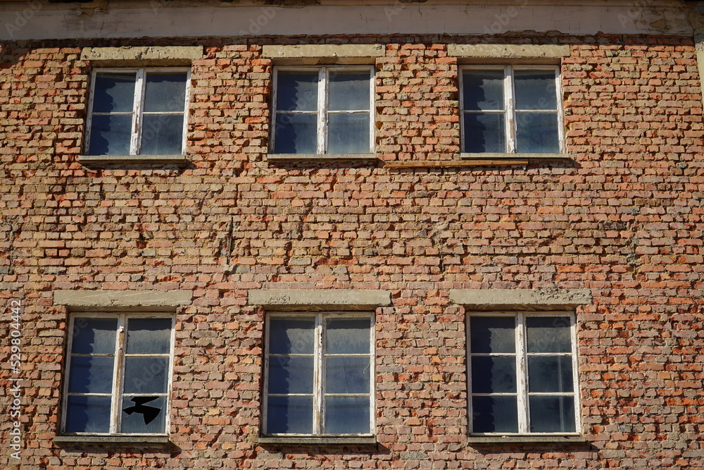Pattern of a red brick wall structure as background, old house facade with simple windows. Old town of Plauen, Vogtlandkreis, Free state of Saxony, Germany.
