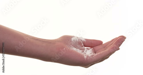 White talcum baby powder being poured on woman's hand. Isolated on a white background. Closeup.