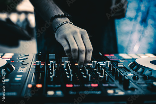 Fotografie DJ Hands creating and regulating music on dj console mixer in concert outdoor
