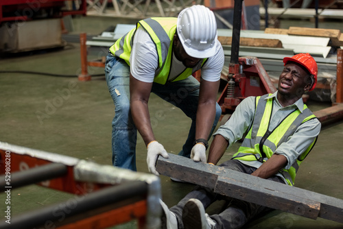Industrial accident concept. Male african american accidents from working carrying heavy objects on legs in Industrial factory.
