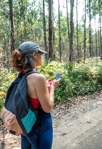 Girl looking at the hiking route on her cell phone