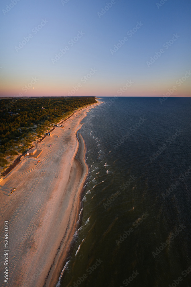 Sea beach on the Baltic Sea. The coastline at sunset. Vertical frame