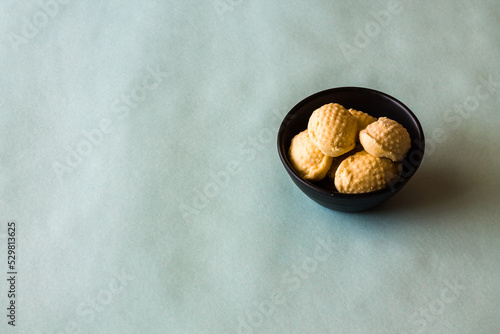 Top view,close-up of Lychee Sandesh or Sondesh  served in a black bowl and isolated on a light blue background. Sandesh is a famous Bengali Sweet or an Indian dessert from West Bengal.   photo