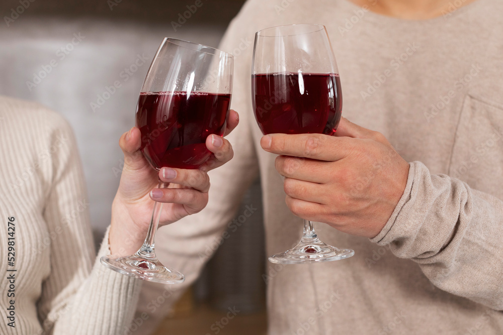 Unrecognizable spouses enjoying time together, drinking wine, cropped