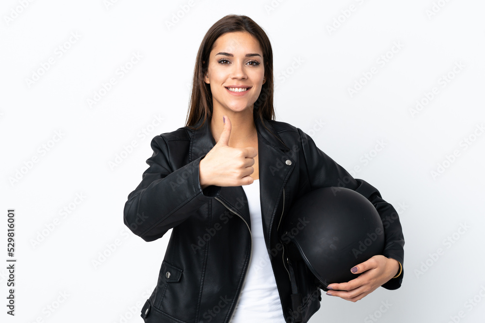 Caucasian girl holding a motorcycle helmet on white background giving a thumbs up gesture Caucasian girl holding a motorcycle helmet on white background giving a thumbs up gesture