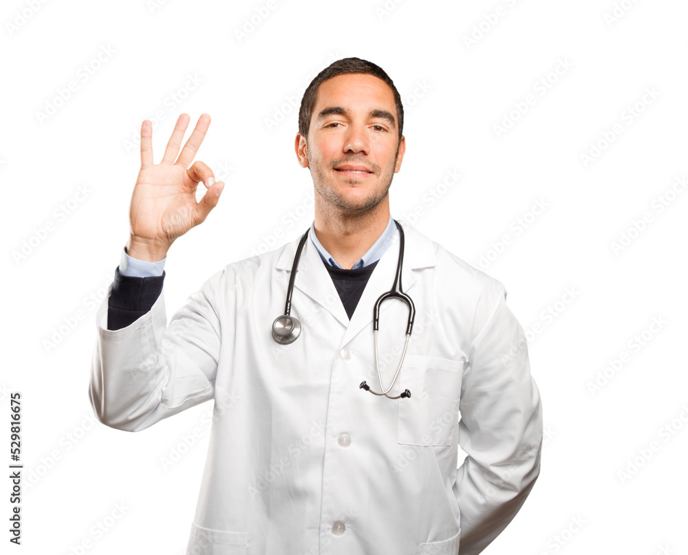 Satisfied doctor with an okay gesture against white background Satisfied doctor with an okay gesture against white background