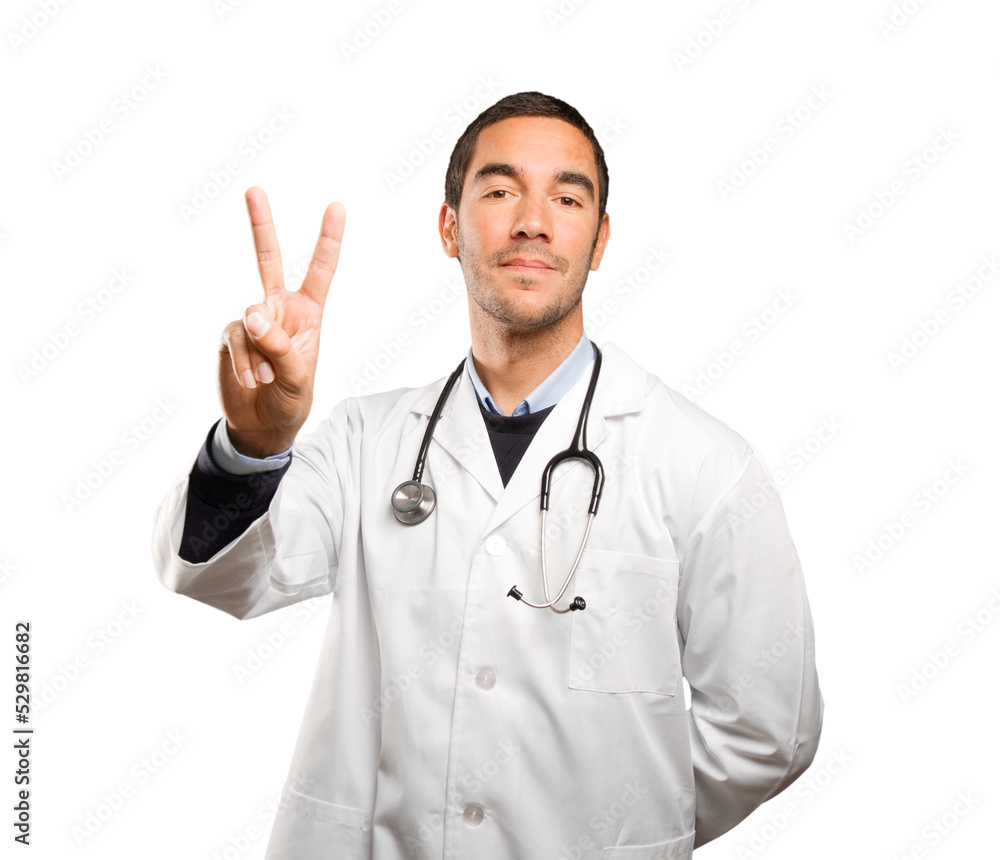 Happy doctor with a victory gesture against white background Happy doctor with a victory gesture against white background