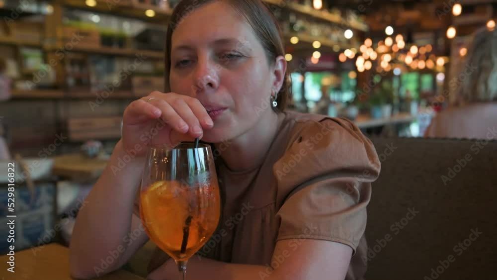 Woman drinking cocktail through the straw in restaurant. 4k video footage in slow motion Woman drinking cocktail through the straw in restaurant. 4k video footage in slow motion