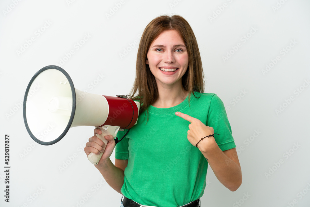 Young English woman isolated on white background holding a megaphone and with surprise facial expression Young English woman isolated on white background holding a megaphone and with surprise facial expression