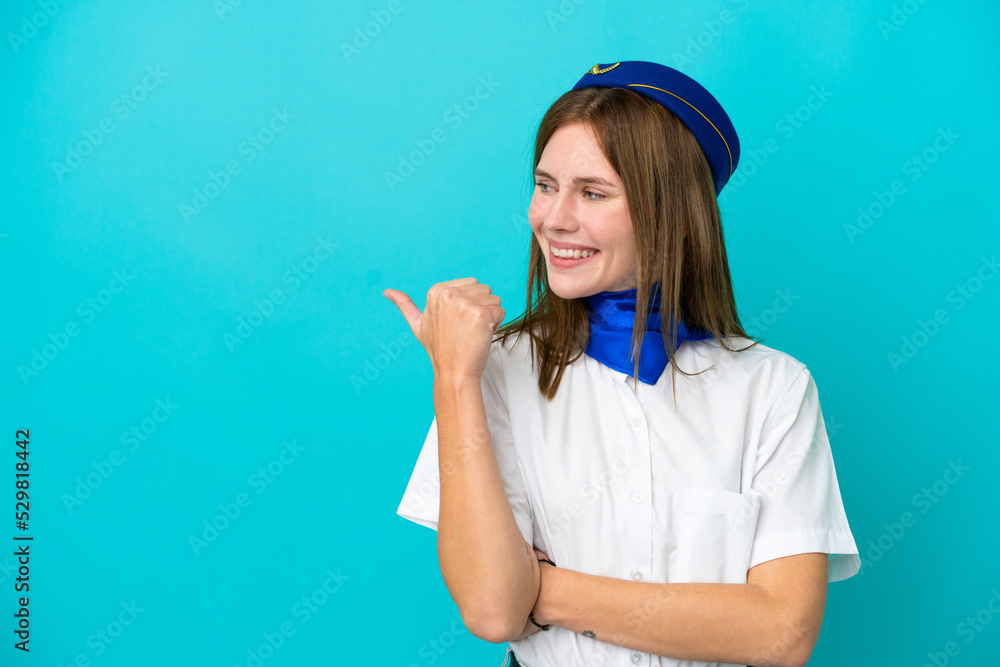 Airplane stewardess English woman isolated on blue background pointing to the side to present a product Airplane stewardess English woman isolated on blue background pointing to the side to present a product