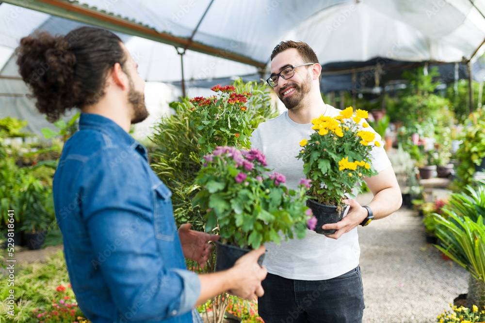 Excited man and his partner laughing while buying flowers