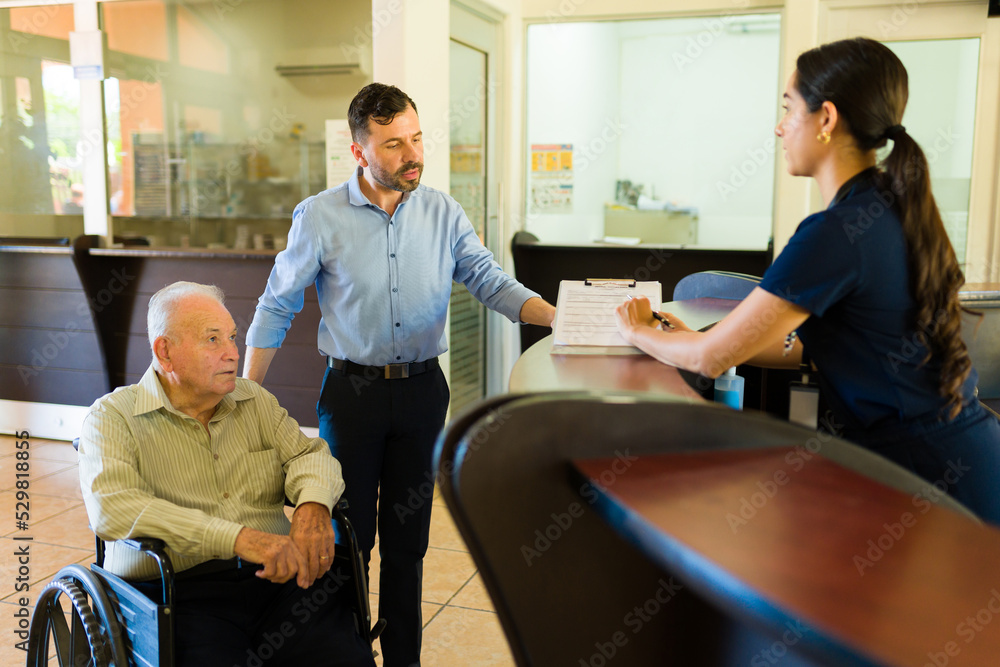 Retired elderly man at the nursing home filing a registration form Retired elderly man at the nursing home filing a registration form