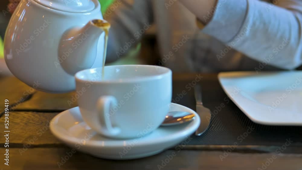 Woman pours hot tea in a white ceramic cup. 4k video footage Woman pours hot tea in a white ceramic cup. 4k video footage