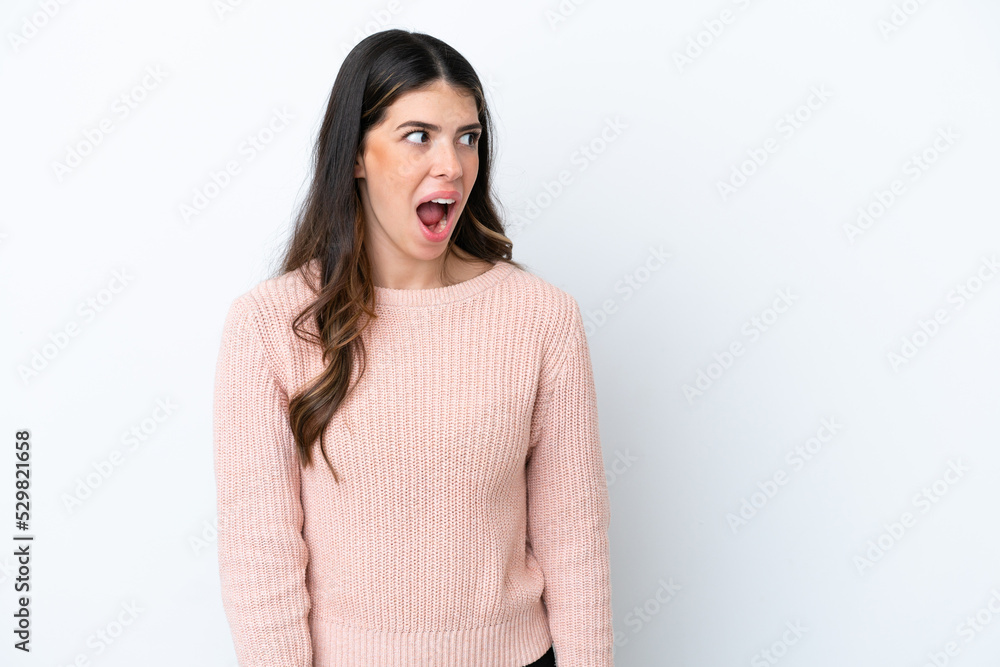Young Italian woman isolated on white background doing surprise gesture while looking to the side Young Italian woman isolated on white background doing surprise gesture while looking to the side