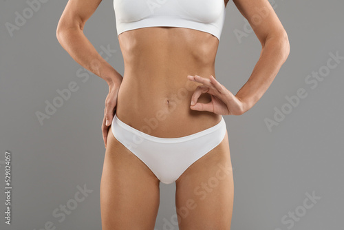 Woman Health. Young slim woman wearing white underwear showing ok gesture