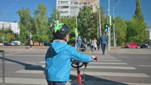 Boy crossing the road with bicycle in the evening. Boy on crosswalk. 4k video footage UHD 3840x2160