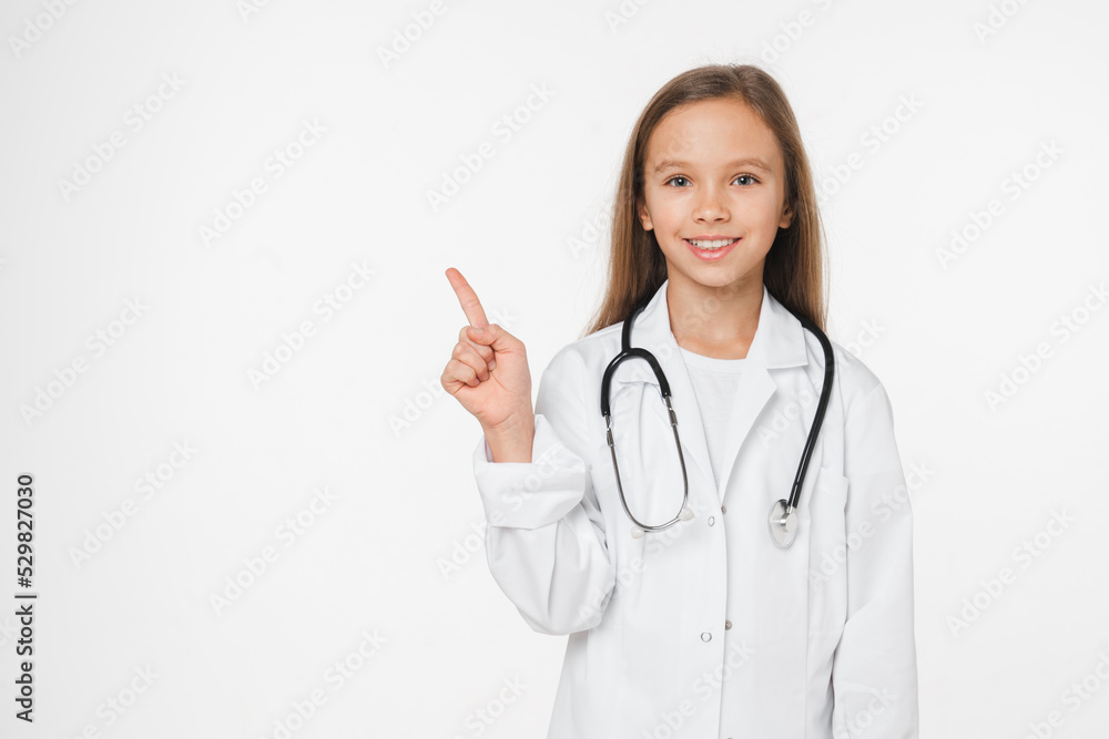 Young teenager preteen caucasian girl schoolgirl in medical coat like a doctor pointing showing copyspace isolated in white background. Medicine hospital concept Young teenager preteen caucasian girl schoolgirl in medical coat like a doctor pointing showing copyspace isolated in white background. Medicine hospital concept