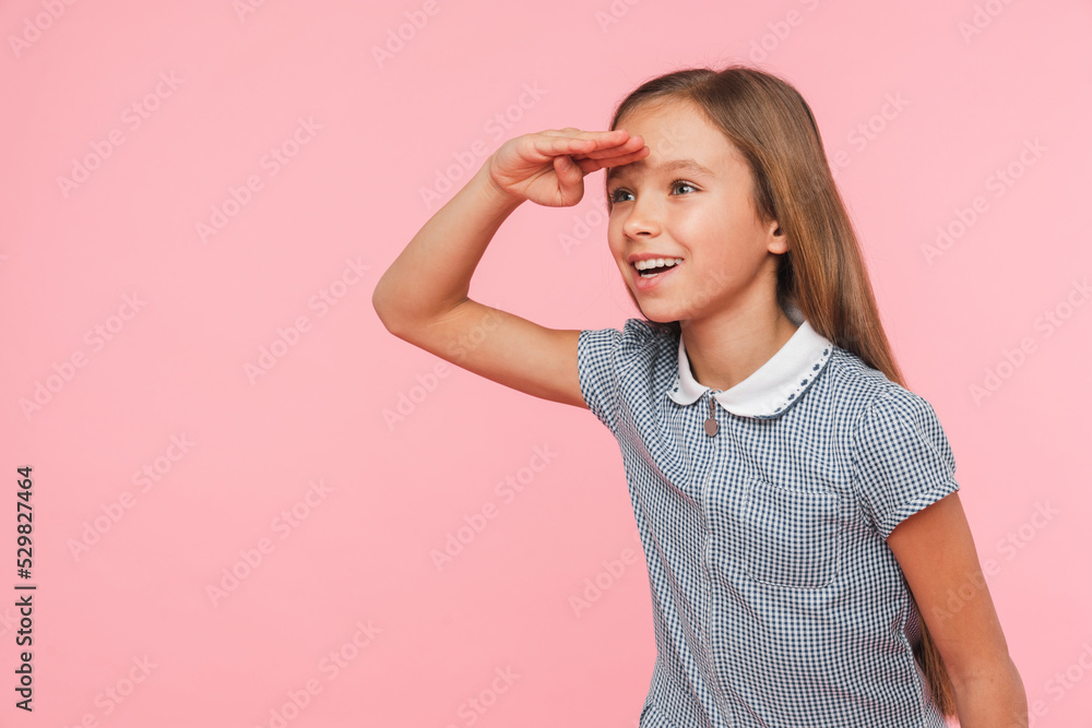 Curious happy caucasian young schoolgirl daughter looking far away with her arm on forehead isolated in pink background. New beginnings, horizon Curious happy caucasian young schoolgirl daughter looking far away with her arm on forehead isolated in pink background. New beginnings, horizon