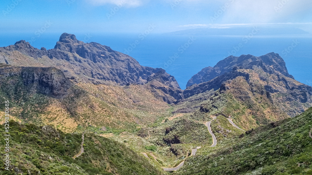 Fototapeta premium Scenic view on the steep canyon of Teno mountain massif, Tenerife, Canary Islands, Spain, Europe. Hiking trail between village Masca and Santiago del Teide. Mountain road next to Roque de la Fortaleza